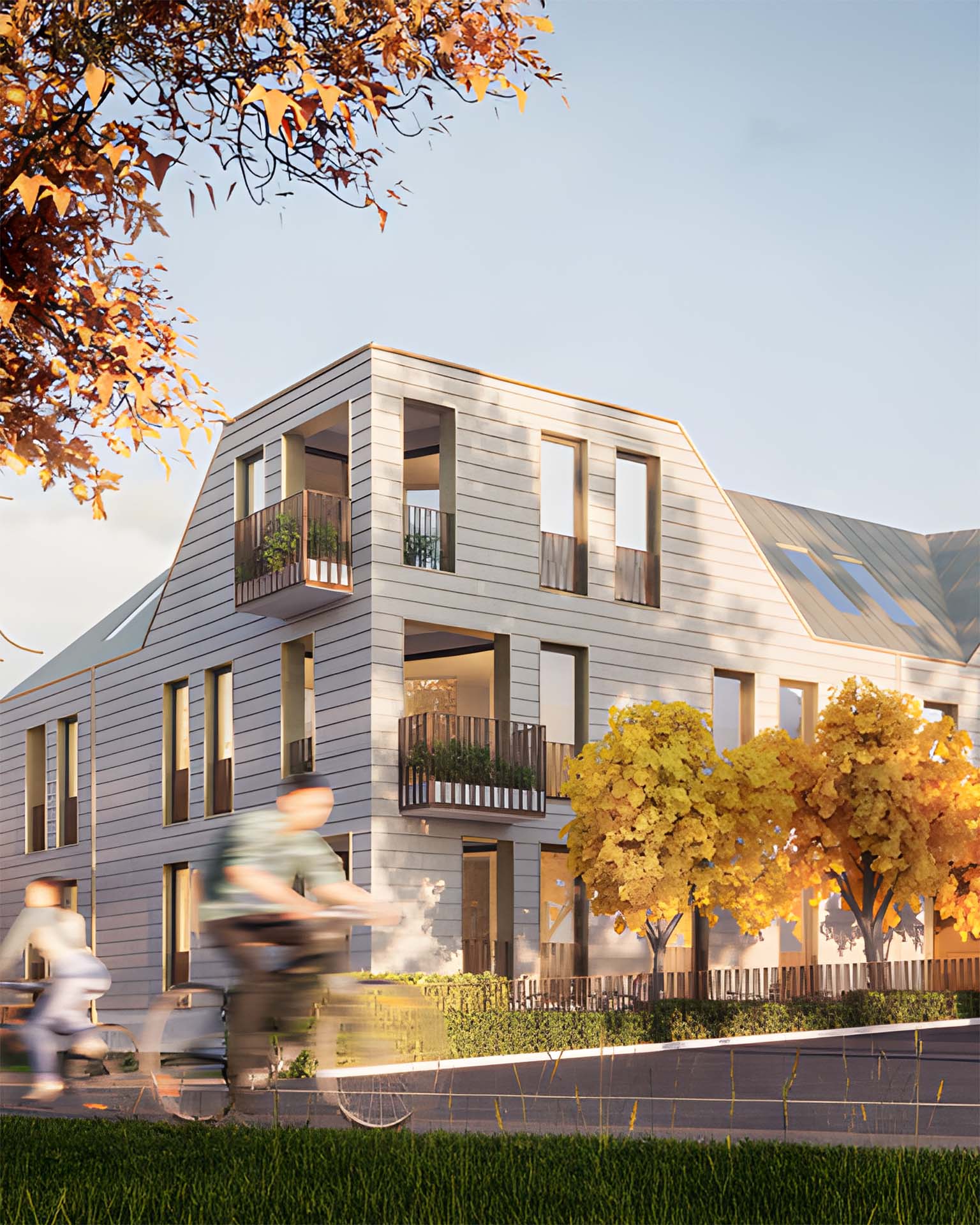 Modernes, mehrstöckiges Wohngebäude mit großen Fenstern und Balkonen in herbstlicher Umgebung – im Vordergrund fahren Menschen mit dem Fahrrad und Auto vorbei