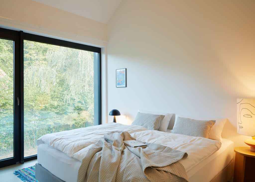 Modernes Schlafzimmer mit Doppelbett und Balkonblick